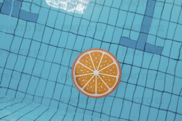 Blue swimming pool from above, an orange tray floats in it