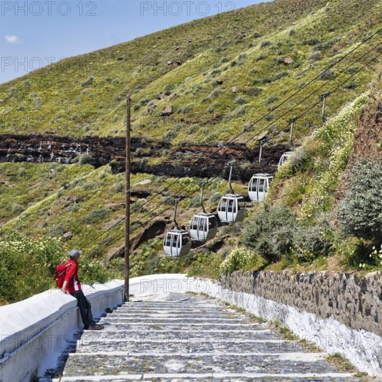 Hiker on stairs, old road to the harbour of the capital Fira, cable car, Thira, Santorini,