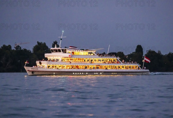 Brightly illuminated passenger ship VORARLBERG underway on Lake Constance during the blue hour.