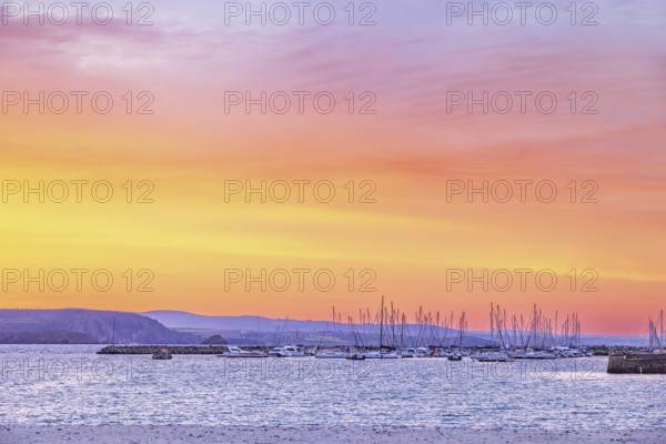 Marina with pleasure boats at a beautiful sunset over the sea and the rocky coastline a summer