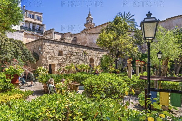 People visit The Arab baths in the old town in Palma de Mallorca an old botanical garden with lush