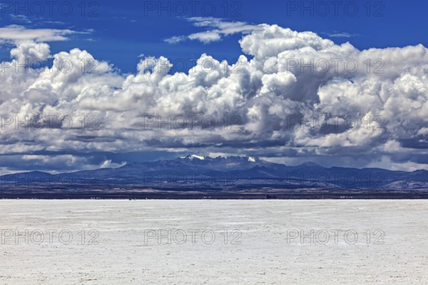 Scenic salt flat with dramatic clouds and distant mountain peaks on the horizon, The endless