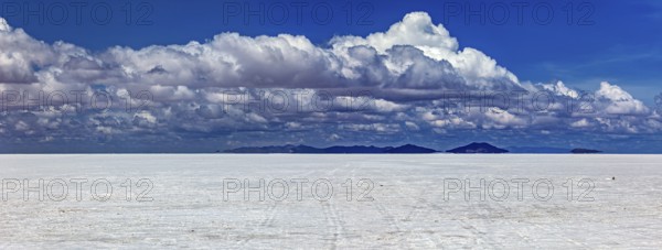 Wide cloud formation over a vast salt flat with distant mountain ranges, The endless expanses of