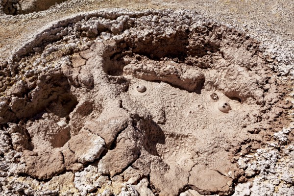 Red, cracked crater with muddy bubbles in a barren environment, The mud volcanoes and fumaroles on