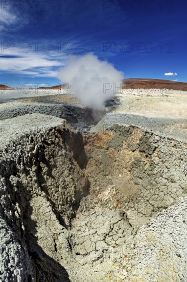 Large crater with steaming geyser in a rocky desert landscape, The mud volcanoes and fumaroles on