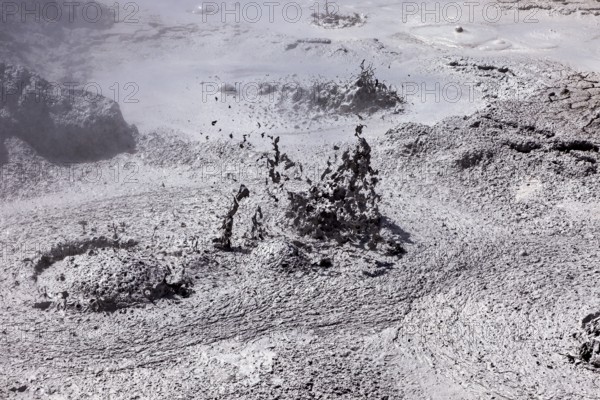 Bubbling mud erupts in a dark geothermal environment, The mud volcanoes and fumaroles on the