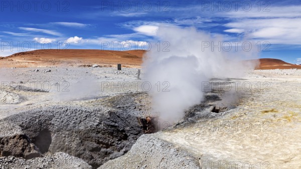 Steam rises from geysers in a rocky desert landscape, sweeping views into the distance, The mud