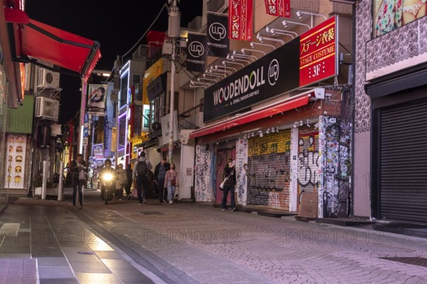 Tourists walk through the narrow alley of Takeshita-dori, Takeshita Street, with souvenir shops and