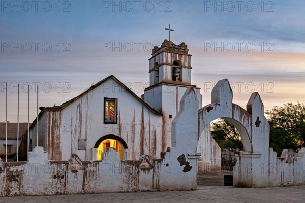 Illuminated church in the evening with warm light and ecclesiastical cross, The church of San Pedro