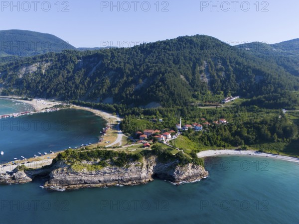 Panoramic view of cliffs and bays with green landscape and calm sea under blue sky, aerial view,