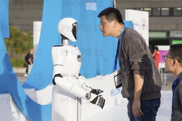 A person looks at a robot at the IFA consumer electronics exhibition on the exhibition grounds,