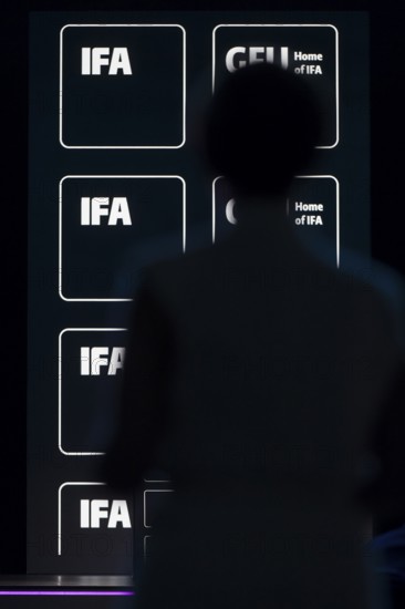 Logos of IFA and GFU behind the silhouette of a person at the opening gala of the IFA