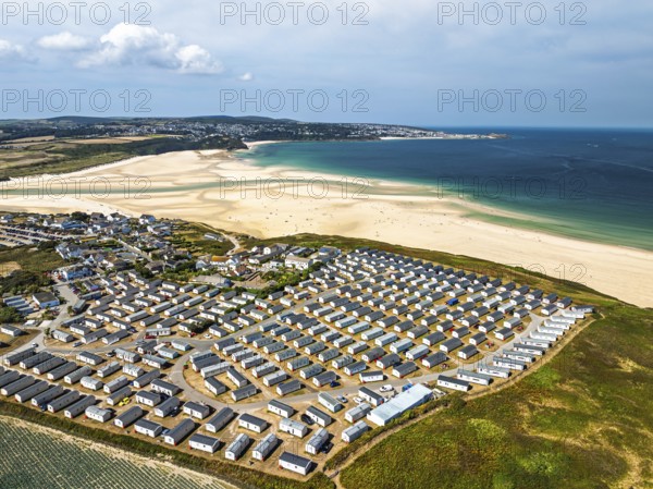 Holiday homes over Hayle Beach and Hayle Estuary from drone, St Ives Bay, Cornwall, England, United