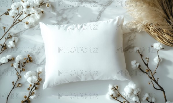 A white pillow on a marble surface framed by cotton branches with soft ambient lighting. AI