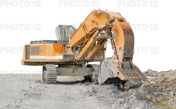 Huge orange colored tracked excavator partly isolated on stony ground
