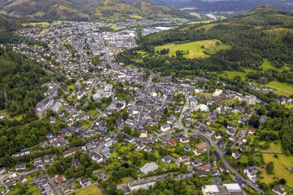 Aerial view, residential area local view, surrounded by hilly forest landscape with forest damage,