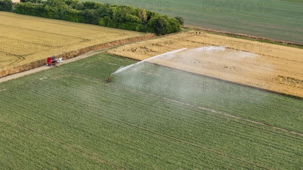 Intensive agricultural irrigation systems using rain gun sprinklers on young soybean crops in the
