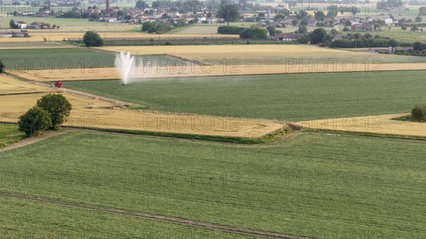 Agricultural irrigation system spraying water on a soybean field during springtime in Italy's