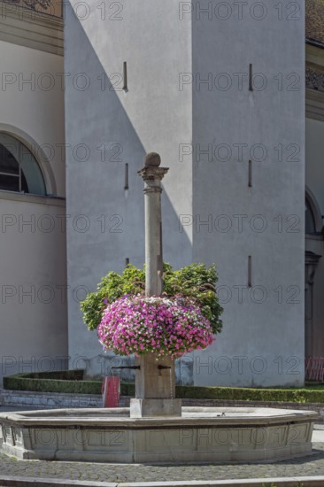 St Martin's Fountain with floral decorations at the parish church of St Martin, Dornbirn,