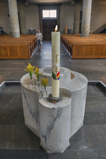 The Roman Catholic parish church of St Martin, interior with baptismal font, candle and floral