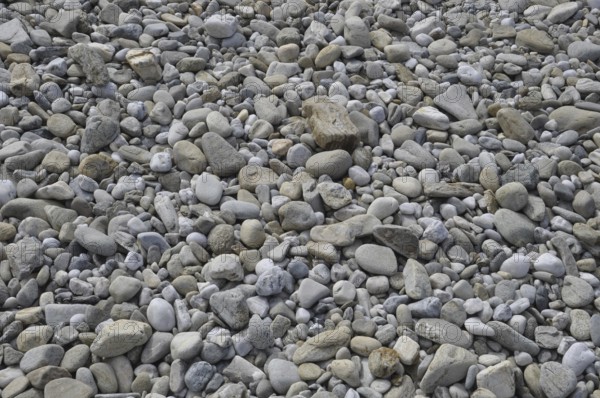 Pebbles background on a beach, A close-up view of a surface covered with various shapes and sizes