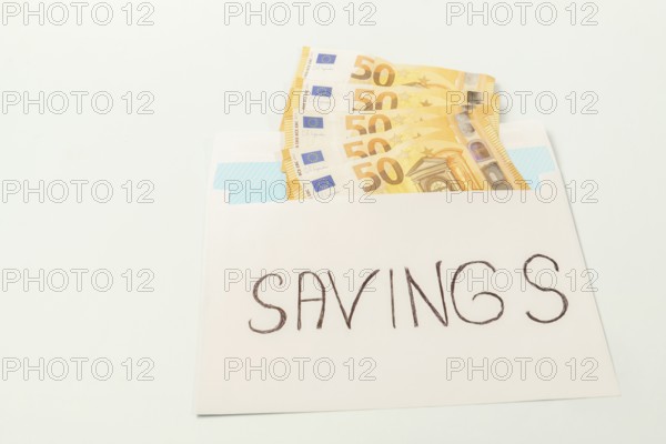 Euro banknotes in an envelope labeled savings illustrating the concept of personal finance and
