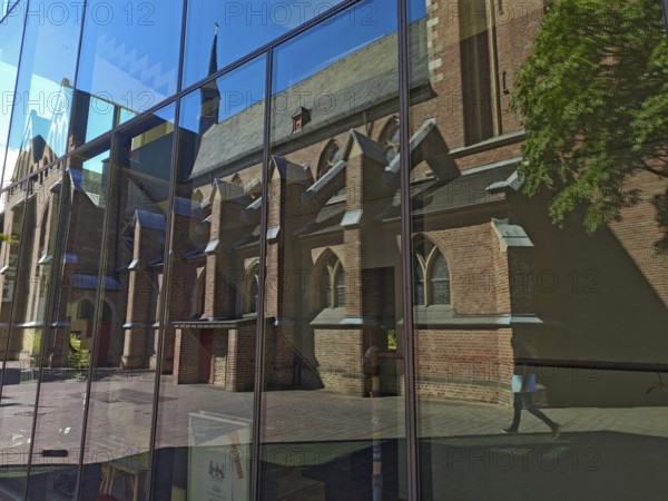 Old town with catholic reflection of St Margaret's Church in glass front, brick building,