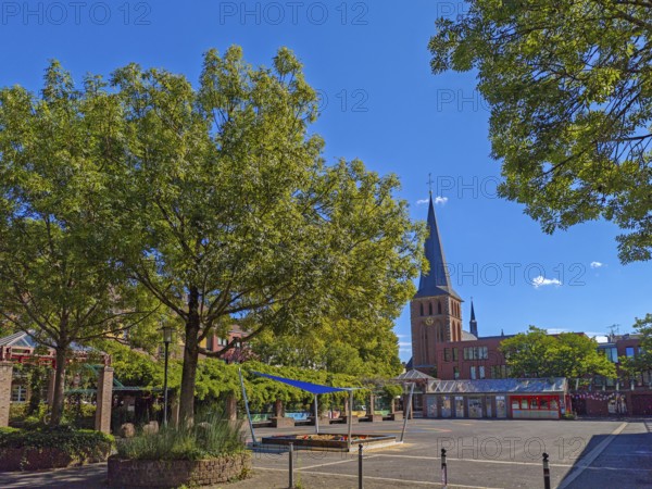Old town with catholic church St. Margareta, brick building, architecture, square with sandpit,