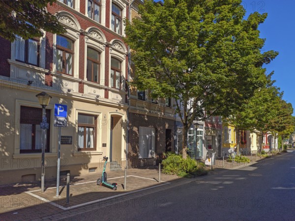 Street in the old town, trees, car park for scooters, e-scooters, blue sky, sunshine, Brühl, North