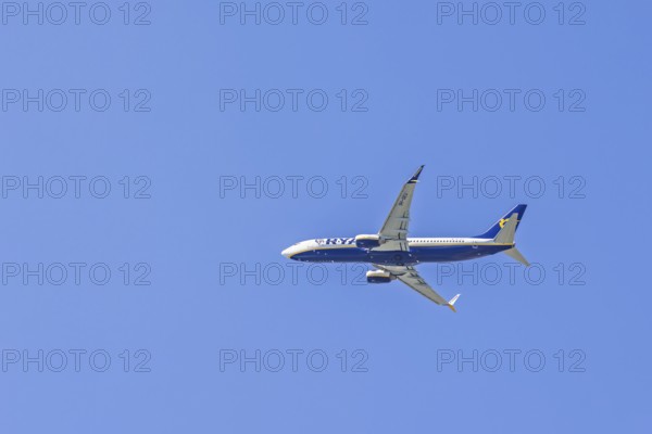 Ryanair passenger plane flying on the blue sky