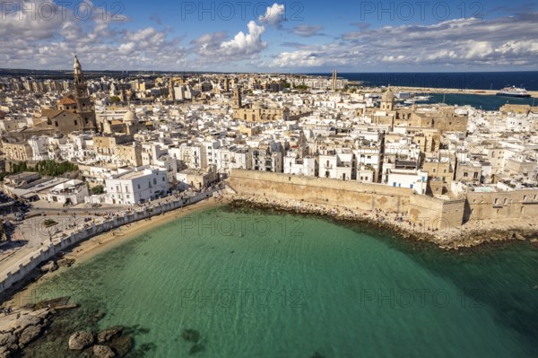 Old town of Monopoli with the cathedral, city walls and Cala Porta Vecchia beach seen from above,