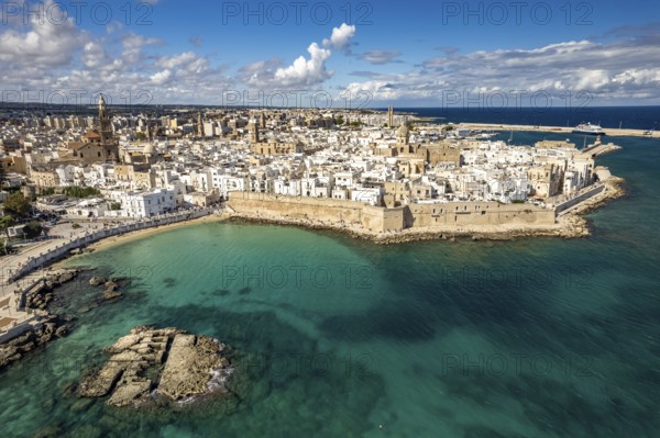 Old town of Monopoli with the cathedral, city walls and Cala Porta Vecchia beach seen from above,