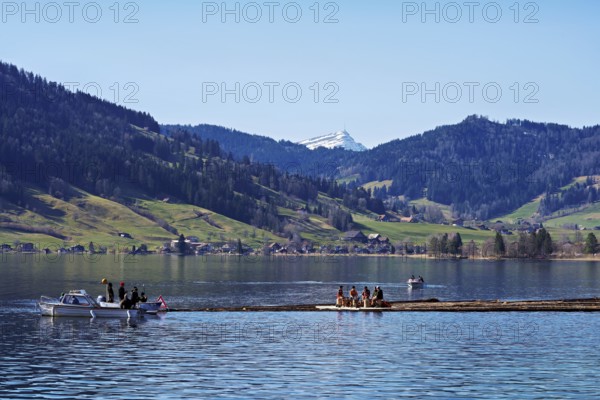 Forestry workers float a raft of felled tree trunks from the Bergmatt across the Ägerisee to the