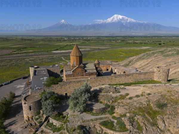 Old church in a green valley with impressive mountain ranges in the background, aerial view, Chor