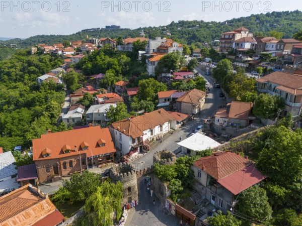 Picturesque village with characteristic red roofs, surrounded by green vegetation and small