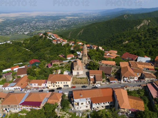 Panorama of a hilly town with a central church and traditional roofs, aerial view, Sighnaghi,