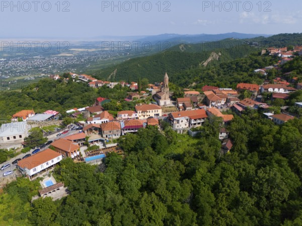 Sweeping view over a hilly region with town and traditional buildings, aerial view, Sighnaghi,