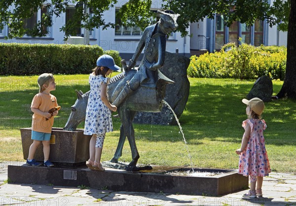 Children at the Münchhausen Fountain by Bruno Schmitz with Münchhausen on the halved horse,