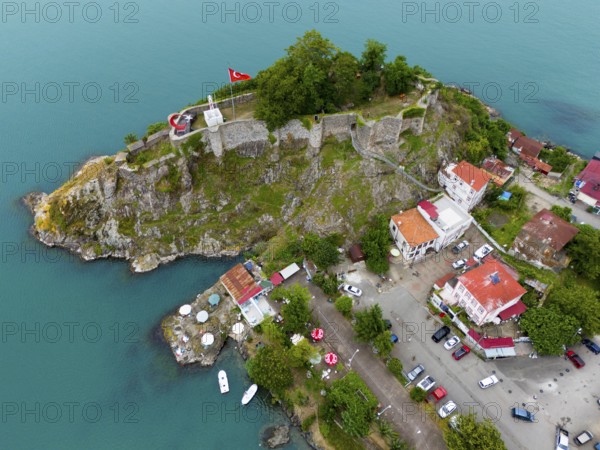 Aerial view of a castle by the sea with Turkish flag and surrounding buildings, aerial view,
