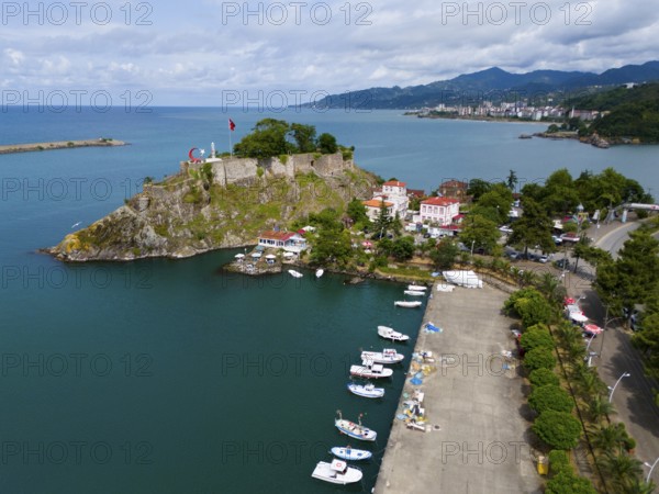 Harbour view with small boats, castle and coastal road next to mountains, aerial view, fortress,