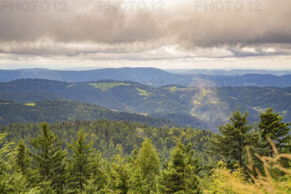 Expansive view of forested mountains under a cloud cover with a misty touch, Mummelsee, Seebach,