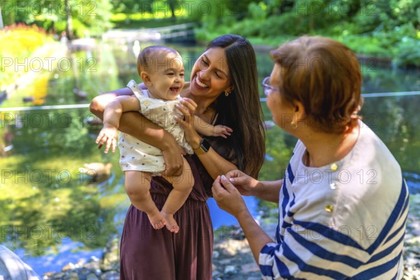 Grandmother, mother and granddaughter spending time together in a park, enjoying the summer and