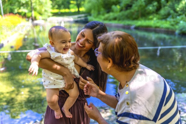 Latin family, including a grandmother, mother, and baby daughter, are enjoying quality time