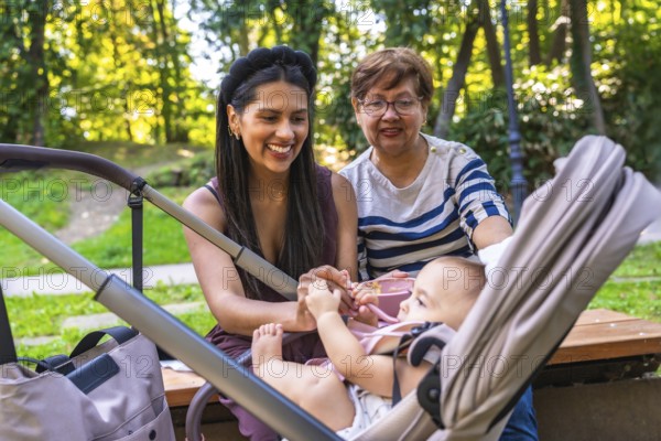 Grandmother, mother, and baby girl enjoying quality time together in a park, highlighting the joys