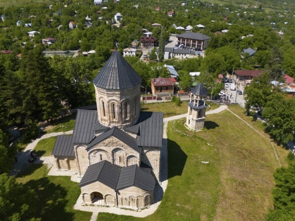 Aerial view of a church with surrounding buildings and green vegetation in a village, aerial view,