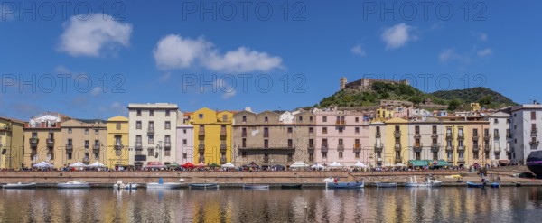 Sardinia, panoramic photo with houses and promenade on the river Temo, guests at the restaurants