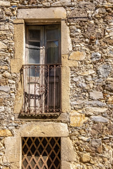 Sardinia, house facade with balcony and weathered wooden balcony door, brown balcony lattice, Santu