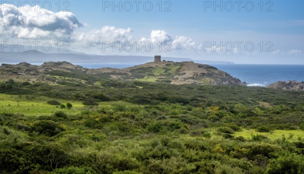 Sardinia, Former fortress tower, hilly coastal landscape by the sea, blue sky with clouds, Bosa,