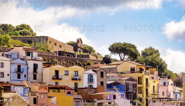 Sardinia, picturesque view of Bosa with pavilions on the promenade, residential buildings and