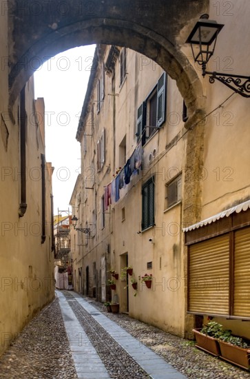 Sardinia, Narrow cobblestone alley and houses in the old town, Laundry by the window, Alghero,